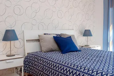 a bedroom with a bed with blue pillows and two lamps at Sunny view to the Tower in Porto