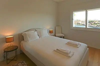 a bedroom with a white bed with towels on it at Villa D'Ouro in Porto