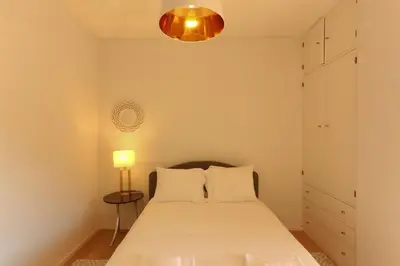 a bedroom with a white bed and a lamp at Villa D'Ouro in Porto