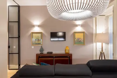 a living room with a couch and a large chandelier at Porto Garden Studio - Santa Catarina in Porto