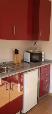 a kitchen with red cabinets and a microwave at D'OURO DONA MARIA By LW in Vila Nova de Gaia