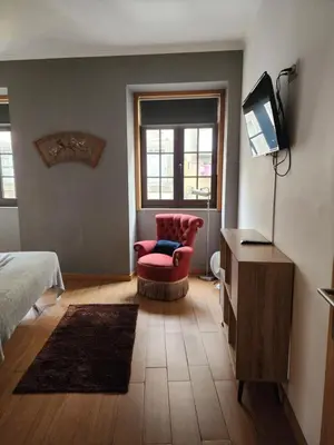 a bedroom with a bed and a chair and a television at D'OURO DONA MARIA By LW in Vila Nova de Gaia