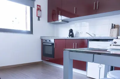 a kitchen with red and white cabinets and a sink at D'OURO DONA MARIA By LW in Vila Nova de Gaia