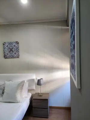 a bedroom with a bed and a table with a lamp at D'OURO DOM MANUEL By LW in Vila Nova de Gaia