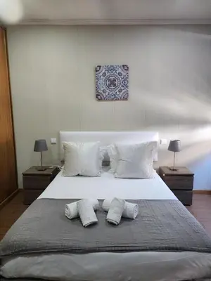 a large white bed with three pillows on it at D'OURO DOM MANUEL By LW in Vila Nova de Gaia