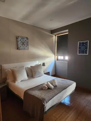 a bedroom with a bed with two shoes on it at D'OURO DOM MANUEL By LW in Vila Nova de Gaia