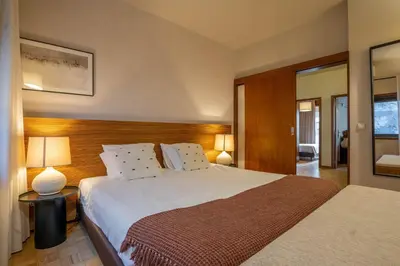 a bedroom with a large bed and two lamps at Firmeza388 Charming Flats - Comfort & Privacy with 2 Bedrooms in Porto