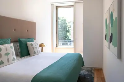 a patio with a stone wall and a stair railing at Porto Deluxe Apartments in Porto