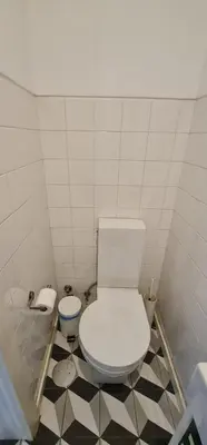 a bathroom with a white toilet and a black and white floor at Downtown Fantail in Porto
