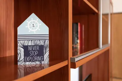 a sign that says never stop exploring on a book shelf at Porto City Experience in Porto