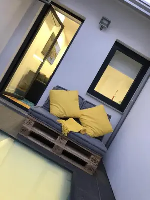 a couch with yellow pillows sitting in a room at TMB (Train / Metro& Bus ) Oporto Station House in Porto