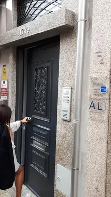 a woman walking past a door of a building at TMB (Train / Metro& Bus ) Oporto Station House in Porto