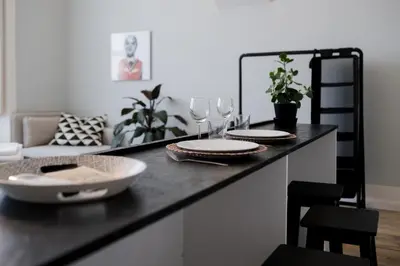 a counter with two plates and wine glasses on it at Baixa24 •P2R• Bright Apt in Vibrant Downtown in Porto