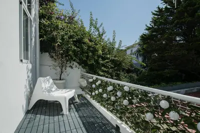 a white chair sitting on a balcony with plants at Baixa24 •P1L• Amplo estúdio na baixa com varanda in Porto