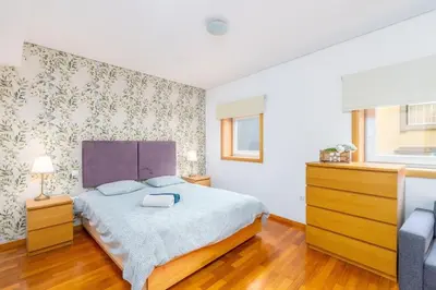 a bedroom with a large bed and a dresser at Cedofeita Paradise w parking included in Porto