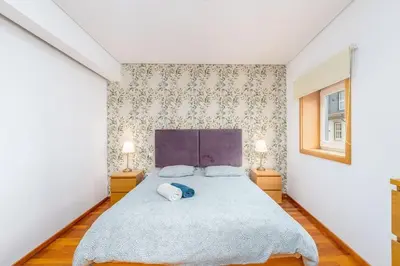 a bedroom with a large bed with two lamps at Cedofeita Paradise w parking included in Porto
