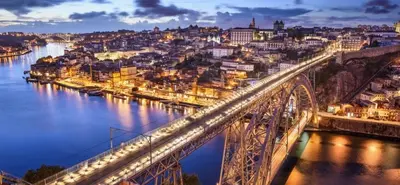 a bridge over a river with a city at night at Oporto Cozy Rooms in Porto