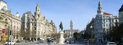 a city street with a statue in front of buildings at Oporto Cozy Rooms in Porto