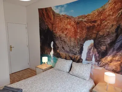 a bedroom with a cliff mural on the wall at Oporto Cozy Rooms in Porto