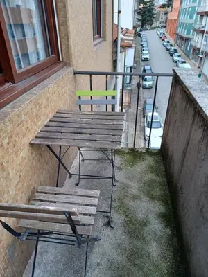 a picnic table and bench on a balcony with a street at Oporto Cozy Rooms in Porto