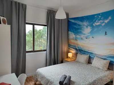 a bedroom with a bed with a painting on the wall at Oporto Cozy Rooms in Porto
