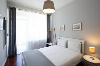 a bedroom with a white bed and a window at Lolla's City House in Porto