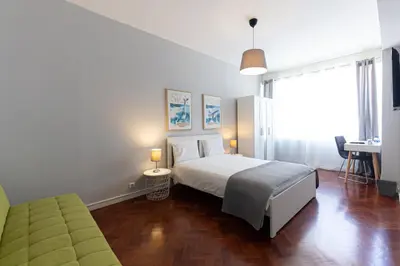 a bedroom with a bed and a desk in it at Lolla's City House in Porto