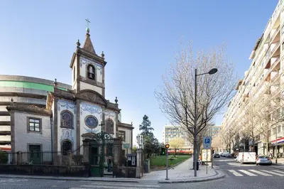 an old church with a clock tower on a street at LovelyStay - Penthouse Balcony Apartment in Porto