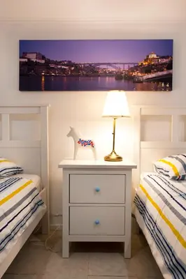 a bedroom with two beds and a table with a lamp at Oporto Blue Trindade - Magical Citycenter Apartment in Porto