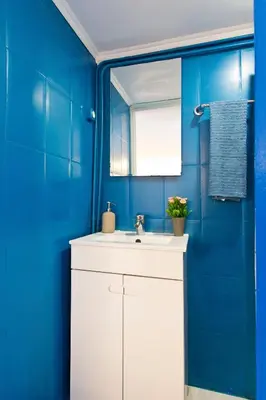 a bathroom with a white sink and blue walls at Oporto Blue Trindade - Magical Citycenter Apartment in Porto