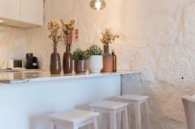 a counter with two stools and vases with flowers on it at Cativo Apartment - Porto Downtown in Porto