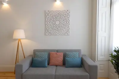a living room with a gray couch with pillows at FLH Living Oporto Lofts in Porto