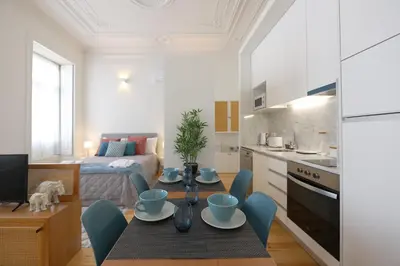 a kitchen and living room with a table and chairs at FLH Living Oporto Lofts in Porto