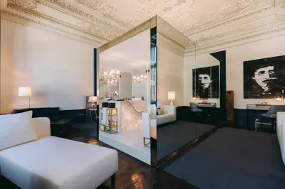 a living room with a bed and a mirror at Torel Palace Porto in Porto
