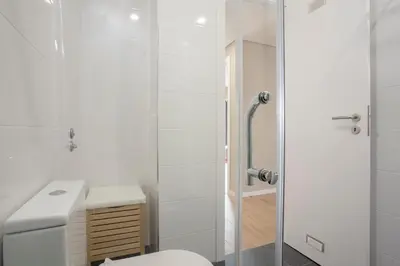 a bedroom with a white bed with a television on the wall at Liiiving in Porto - Terrace Downtown Apartment in Porto