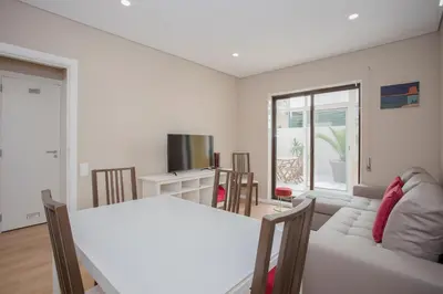 a wooden table and chairs on a patio with palm trees at Liiiving in Porto - Terrace Downtown Apartment in Porto