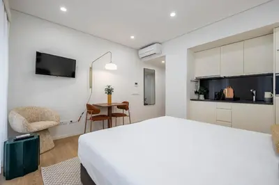 a bedroom with a bed and a table and a mirror at Aspasios Picaria Apartments in Porto