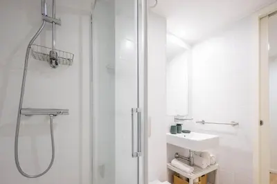 a bathroom with a shower and a toilet and a sink at Aspasios Picaria Apartments in Porto
