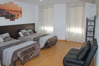 a hotel room with two beds and a chair at D. Duarte I in Porto