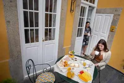a woman sitting at a table with a plate of food at Domus Duorum in Porto
