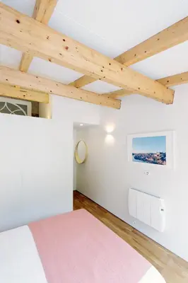a bedroom with white walls and wooden ceilings at HM - Oporto Cedofeita 500C in Porto