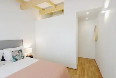 a bedroom with a large white bed and wooden floors at HM - Oporto Cedofeita 500C in Porto