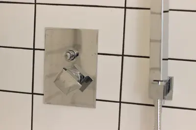 a metal box in a white tiled bathroom at HM - Oporto Cedofeita 500B in Porto