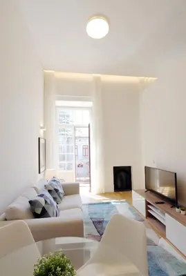 a white living room with a couch and a tv at HM - Oporto Cedofeita 500B in Porto