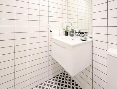 a white bathroom with a sink and a tiled wall at HM - Oporto Cedofeita 500E in Porto