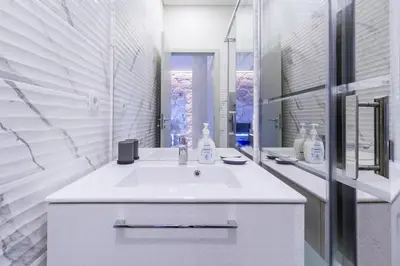 a white bathroom with a sink and a mirror at GuestReady - Charming Downtown and Quiet Apartment in Porto