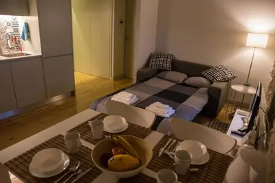 a living room with a bed and a table and chairs at GuestReady - Charming Downtown and Quiet Apartment in Porto