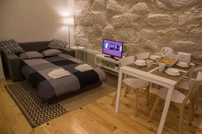 a bedroom with a bed and a table with a computer at GuestReady - Charming Downtown and Quiet Apartment in Porto