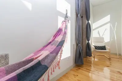 a hanging hammock in a room with a chair at GuestReady - Charming Downtown and Quiet Apartment in Porto