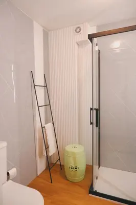 a bathroom with a toilet and a green bucket at Portobello Lux Living in Vila Nova de Gaia